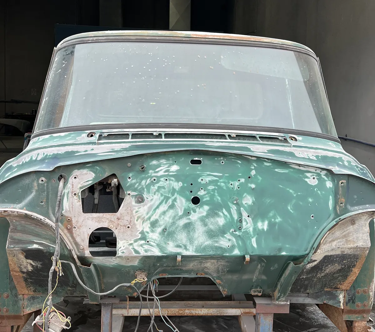 The front of a classic truck cab stripped and sanded on a workshop stand