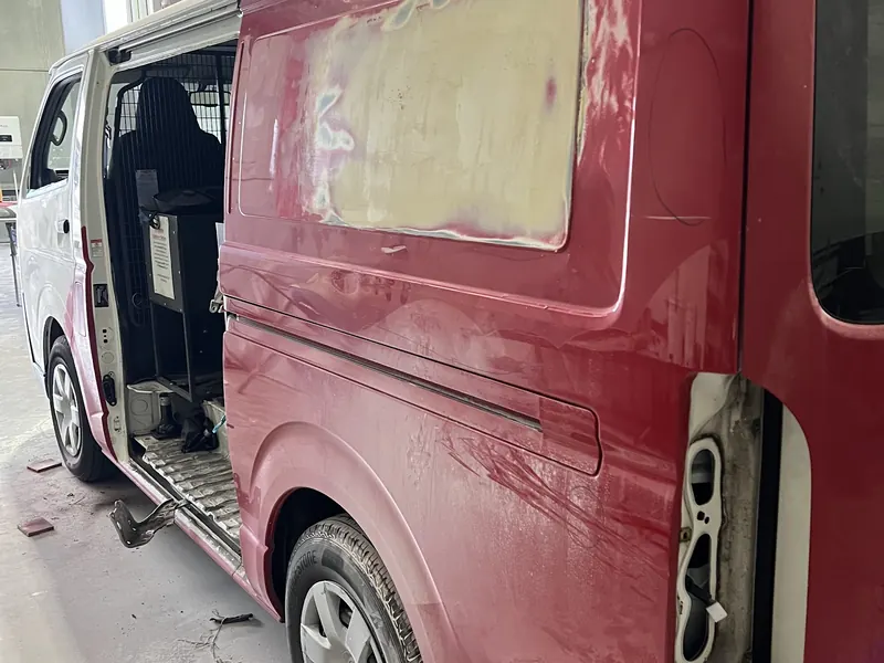 The side of a van filled and sanded in the workshop before paint