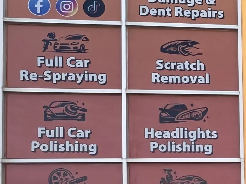 The window signs at M&Z Car Panel Repairs listing dent repairs, respraying, scratch removal, polishing, headlights, wheels and detailing